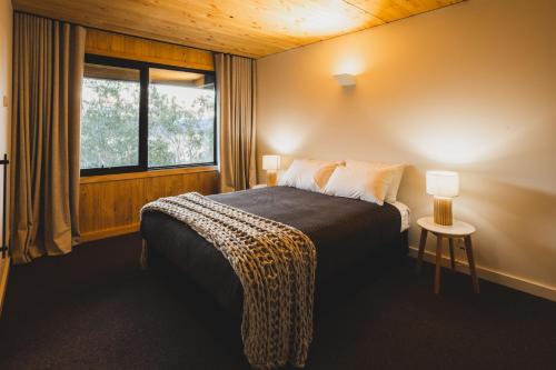 金德拜恩Kunama Townhouses的一间卧室配有一张带窗户和桌子的床