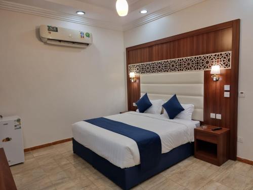 Al Qunfudhahالديار الفاخرة للشقق المخدومة的一间卧室配有一张带蓝白色床单的大床