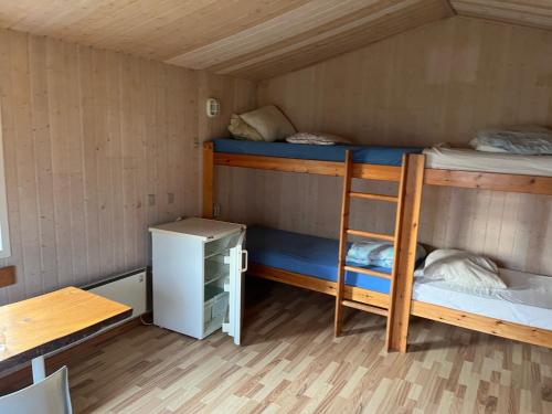 NibeLundby Camping的客房设有两张双层床和一张书桌。