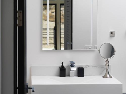 约书亚树Panoramic Heaven - Luxury Designer Property w Spa的浴室设有镜子和白色水槽