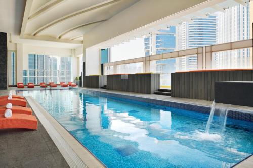 多哈Delta Hotels by Marriott City Center Doha的一座大型游泳池,在一座建筑中设有喷泉