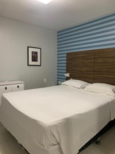 福塔莱萨Iracema Residence Flat - Apto Particular的卧室里一张大白色的床,卧室里设有蓝色的墙壁