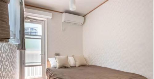 东京メゾン・ド・ミナ的一间小卧室,配有一张带窗户的床