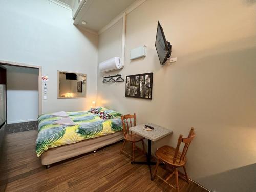 阿米代尔西区公寓的卧室配有一张床和一张桌子及椅子