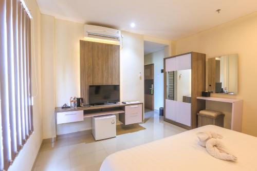 坎古Canggu Dream Village Hotel and Suites的一间设有床铺和电视的房间