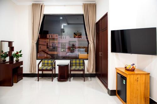 波来古市MINH LÂM HOTEL的客厅配有电视和桌椅