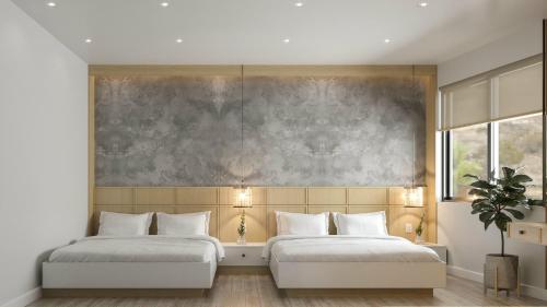 胡志明市Happy Hotel Bình Tân的卧室内的两张床,墙上有绘画作品