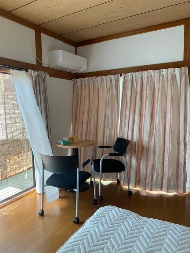 筑紫野市民泊　筑紫野的一间卧室配有桌椅和一张床