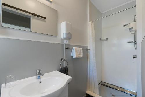陶波Central Inn Taupo的白色的浴室设有水槽和淋浴。