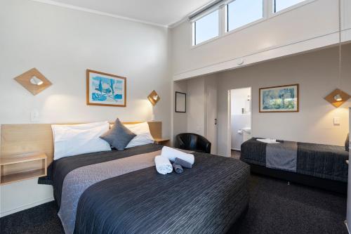 陶波Central Inn Taupo的酒店客房配有两张床和一张书桌