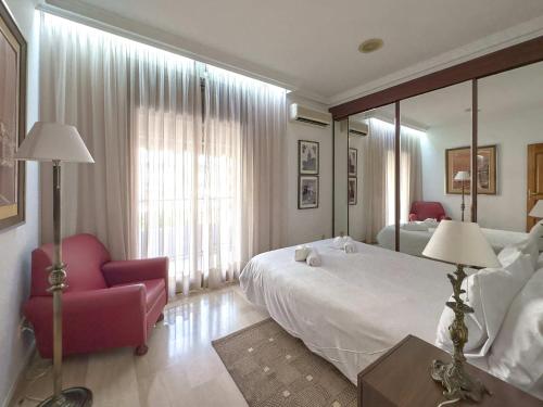 巴塞罗那Stay U-nique House Torre Damians的一间卧室配有一张大床和一张红色椅子