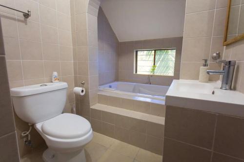 坎昆Tropical house in Downtown Cancún的浴室配有卫生间、盥洗盆和浴缸。