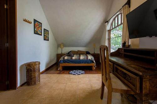 坎昆Tropical house in Downtown Cancún的一间卧室配有一张床,另一间卧室配有钢琴