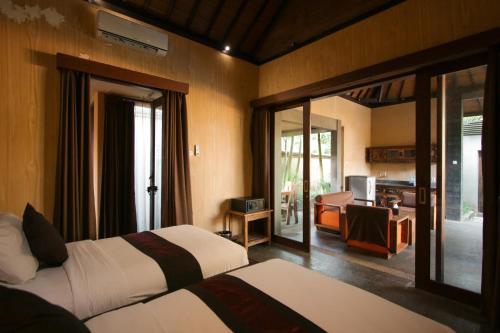 乌布Gino Feruci Villa Ubud by KAGUM Hotels的酒店客房带两张床和一个客厅