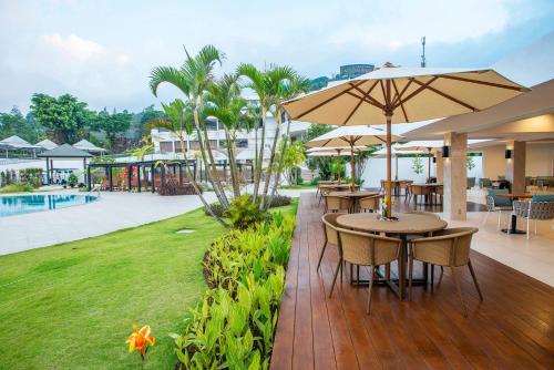 特里特斯Surya Hotel & Cottages Prigen的一个带桌子和遮阳伞的庭院和一个游乐场