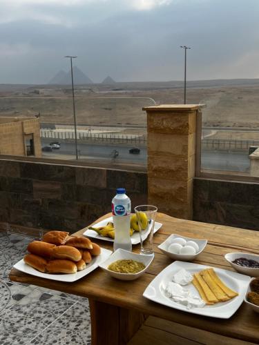 埃兹贝特Pyramids Desert Gate Hotel的一张餐桌,上面放着盘子,享有沙漠美景