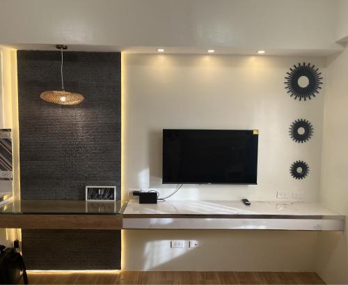 宿务Aesthetic Functional Minimalist Space Sunvida Tower SV1716的客厅设有壁挂式平面电视。