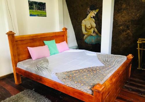 埃拉Ella Camping Resort的一间卧室配有带粉色和绿色枕头的木床