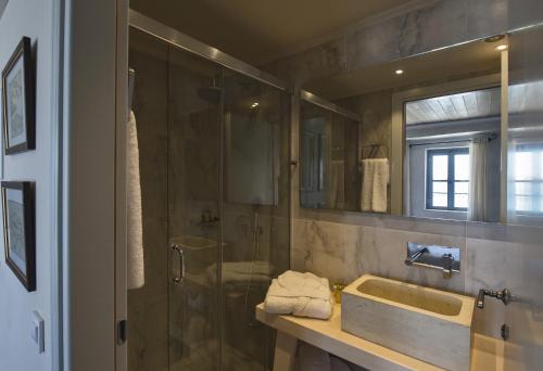 干尼亚Elia Zampeliou Hotel的带淋浴、盥洗盆和镜子的浴室
