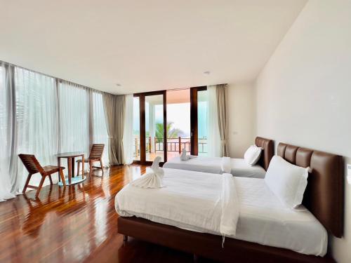 皮皮岛Phi Phi Mountain Beach Resort SHA Certified的一间卧室配有两张床和一张桌子及椅子
