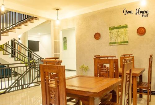 康提Green Heaven Resort Kandy的一间带木桌和椅子的用餐室