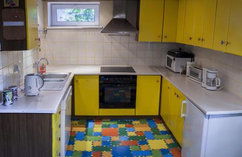 索波特Hostelino的厨房配有黄色橱柜和色彩缤纷的地毯。
