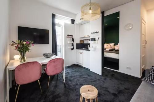 阿姆斯特丹Cozy 2-bedroom apartment的客厅配有桌子和2把粉红色的椅子
