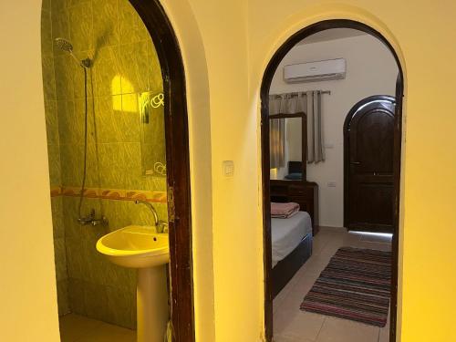 达哈布Malaz Motel的黄色的浴室设有水槽和镜子