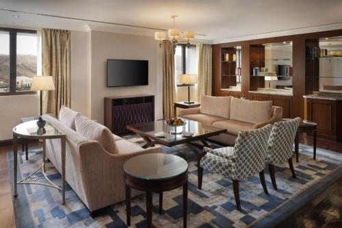 马斯喀特阿曼喜来登酒店的客厅配有沙发、椅子和电视