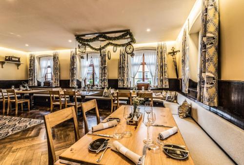 KirchhofenKrone - das Gasthaus的餐厅设有木桌、椅子和窗户。