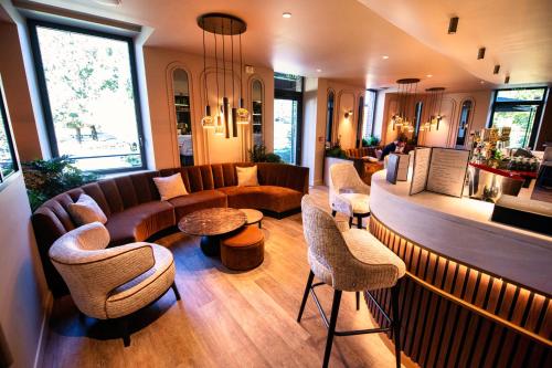 利勒阿当Amicitia - Hôtel & Restaurant的大堂配有沙发、椅子和桌子