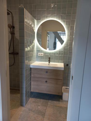 奥门Vakantiewoning - Veurom的一间带水槽和镜子的浴室