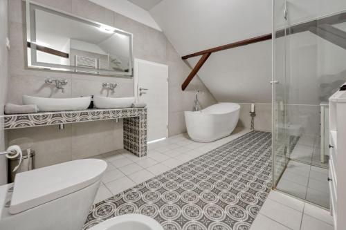 萨格勒布Apartments Old Town Gloria的一间带两个盥洗盆、浴缸和卫生间的浴室