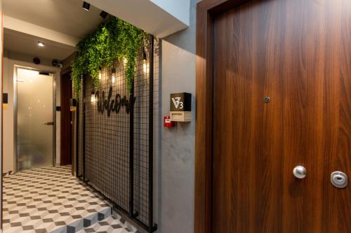 塞萨洛尼基Valaoritou 3 Luxury Rooms的走廊上挂有门,墙上挂着植物