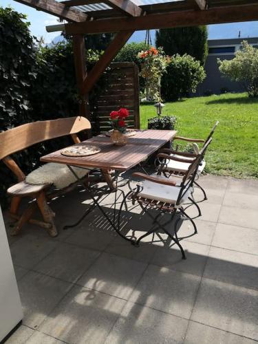 埃申Garten-Wohnung的一张木桌、两把椅子、一张桌子和长凳