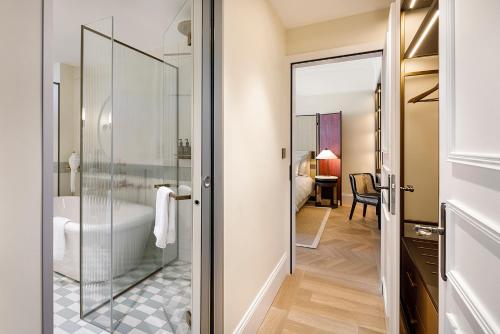 苏黎世苏黎世小型豪华大使酒店的浴室设有玻璃门,可通往卧室
