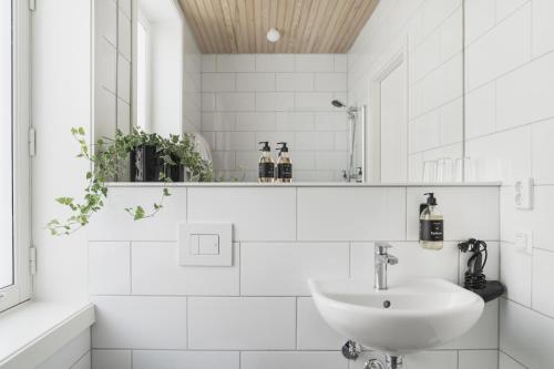 卑尔根Heimen Hotel的白色的浴室设有水槽和镜子
