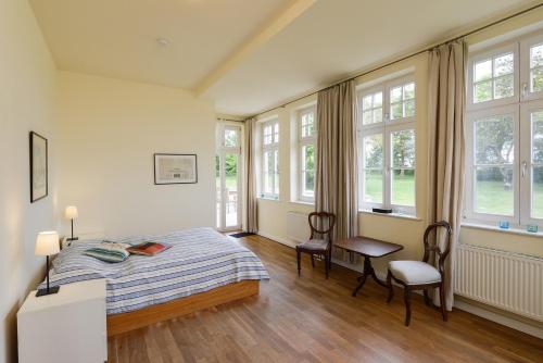 NeuenkirchenFerienwohnung 3 mit gr Terrasse und Wasserblick的卧室配有一张床和一张桌子及椅子