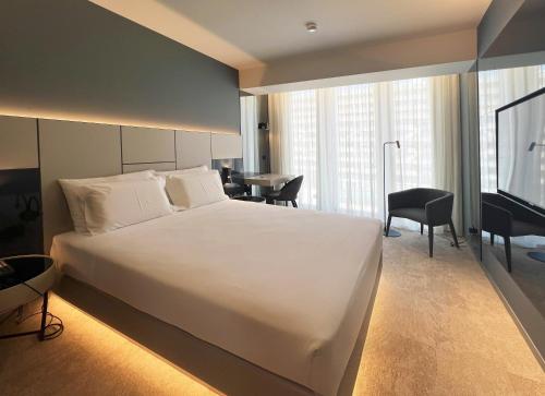 波尔图Oca Bom Sucesso Hotel的卧室配有一张白色大床和一张书桌