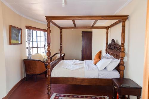 安博塞利Wild Amboseli Ndovu Cottage.的一间卧室配有一张天蓬床和一把椅子