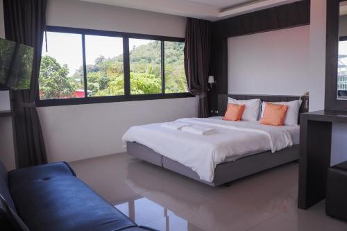 蔻立Rakkawan Residence - SHA EXTRA PLUS的一间卧室设有一张床和一个大窗户