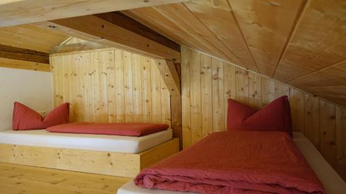 施坦斯Rossweid Huette的木墙客房的两张床