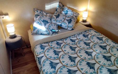 Vielle-TursanAu Temps Suspendu - 3 chambres - Au coeur de la nature - À 10 minutes des commerces的一间卧室配有一张带蓝白色床单和两盏灯的床。