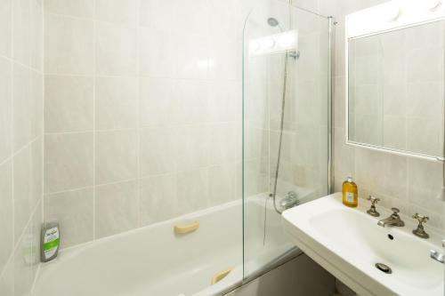 伦敦Cozy 1 bedroom at Notting Hill的白色的浴室设有水槽和淋浴。