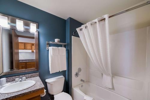 沃思堡WoodSpring Suites Fort Worth Fossil Creek的浴室配有卫生间水槽和淋浴。