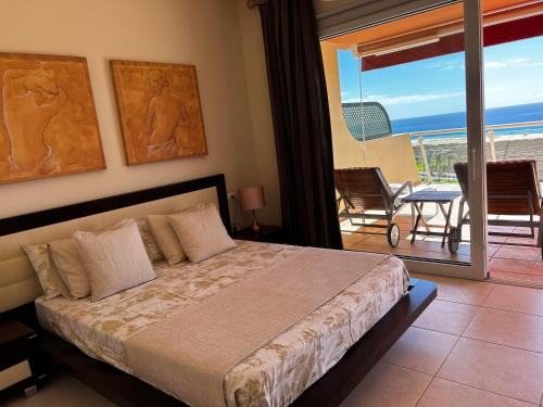 莫罗德哈布雷Terrazas de Jandía的一间卧室配有一张床,享有海景