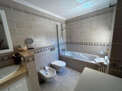 莫罗德哈布雷Terrazas de Jandía的浴室配有卫生间、浴缸和水槽。