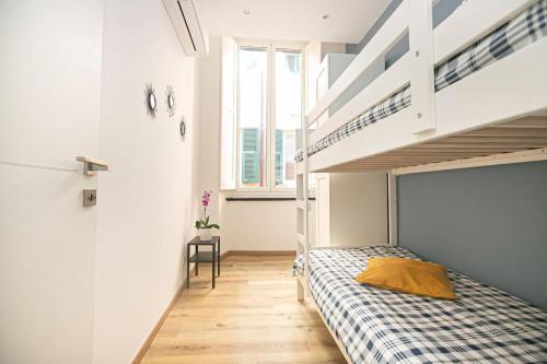 热那亚Porto Antico Exclusive Apartment的一间卧室设有双层床和楼梯。