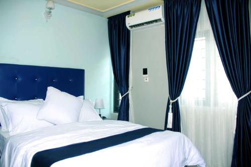 IseyinSILVERZB RESORT的一间卧室配有一张带蓝色窗帘的床和一扇窗户