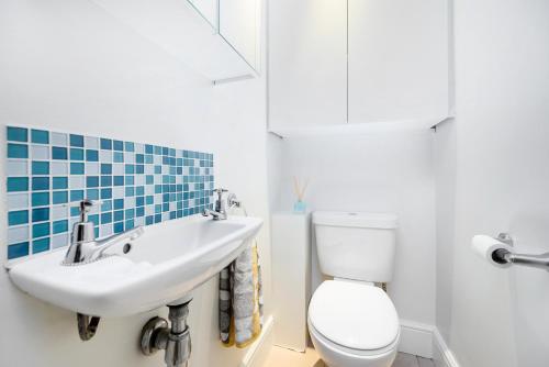 伦敦Modern 3 bedroom house with garden view的浴室配有白色卫生间和盥洗盆。